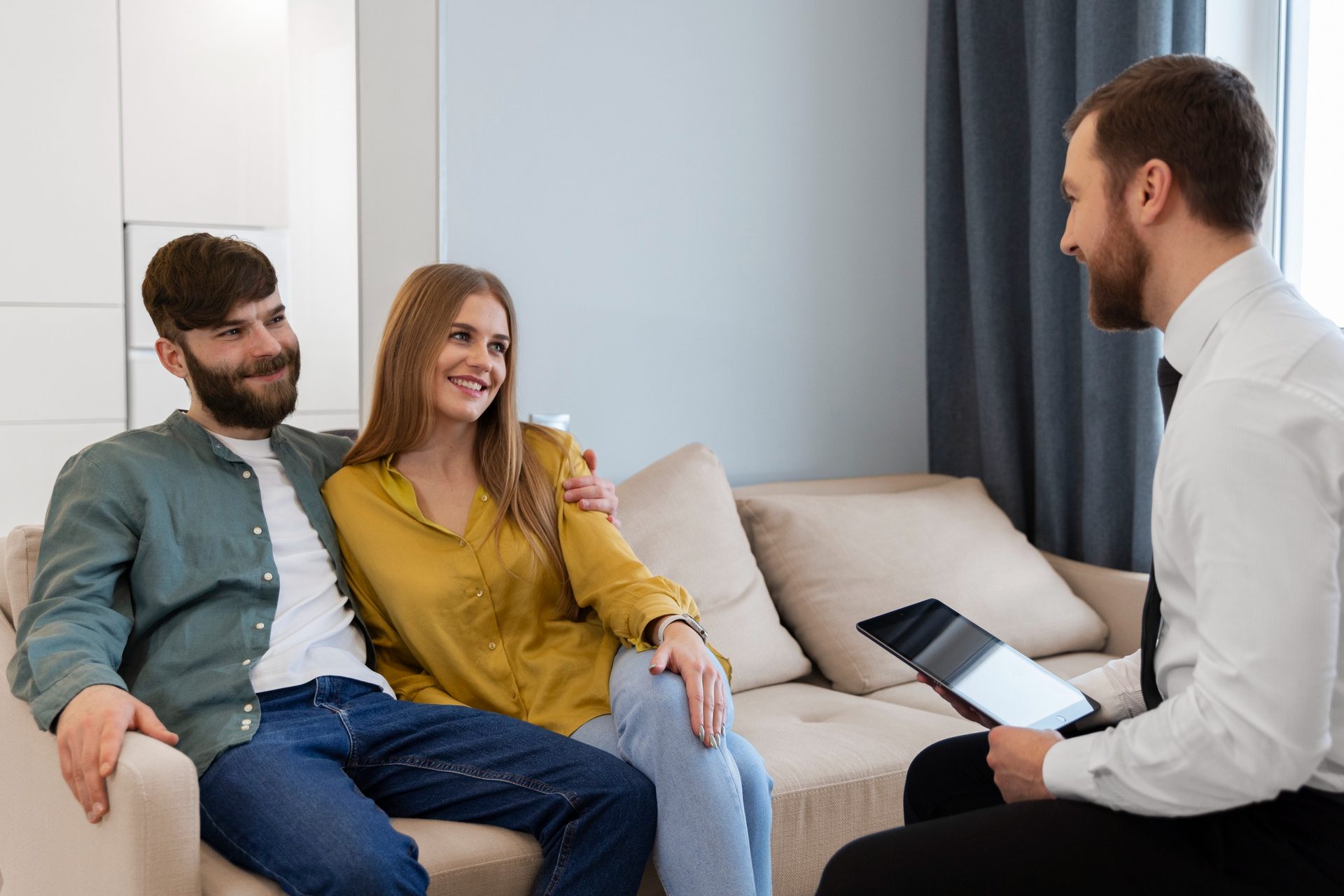 Male real estate agent doing business and showing house to potential buying couple